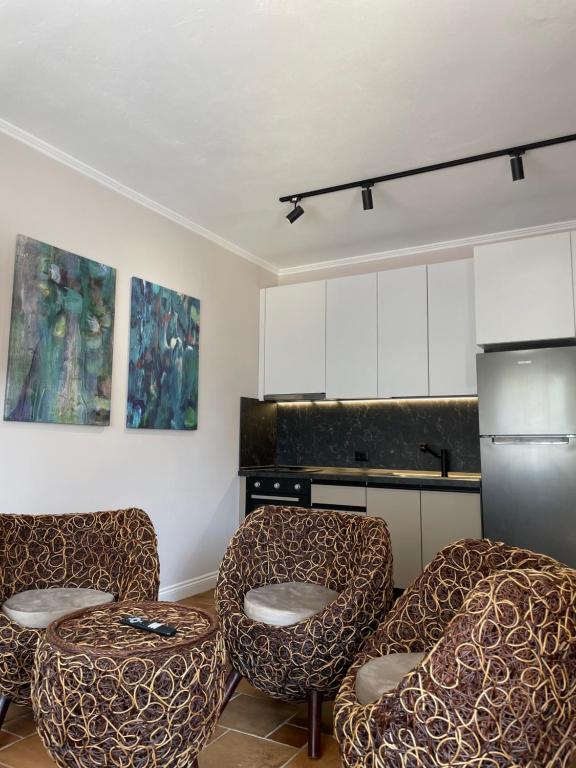 a kitchen with three chairs and a refrigerator at Aquamarine Dreams Apartments in Beach of Durres 150 m from Sea in Durrës