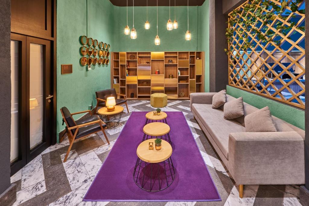 メキシコシティにあるCity Centro by Marriott Ciudad de Mexicoのリビングルーム(ソファ、紫の敷物付)