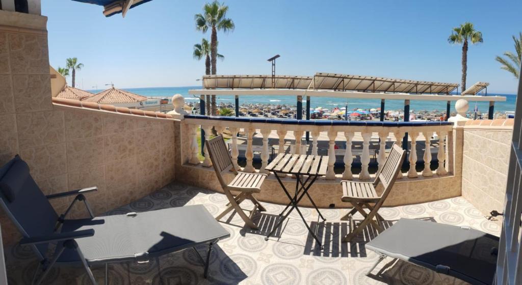 a patio with chairs and tables and the beach at Casita Beach Front in Torrox Costa