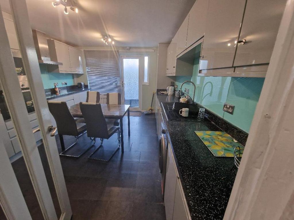 uma cozinha com uma mesa e uma sala de jantar em Luxury House, 4 bedrooms fully furnished em North Woolwich