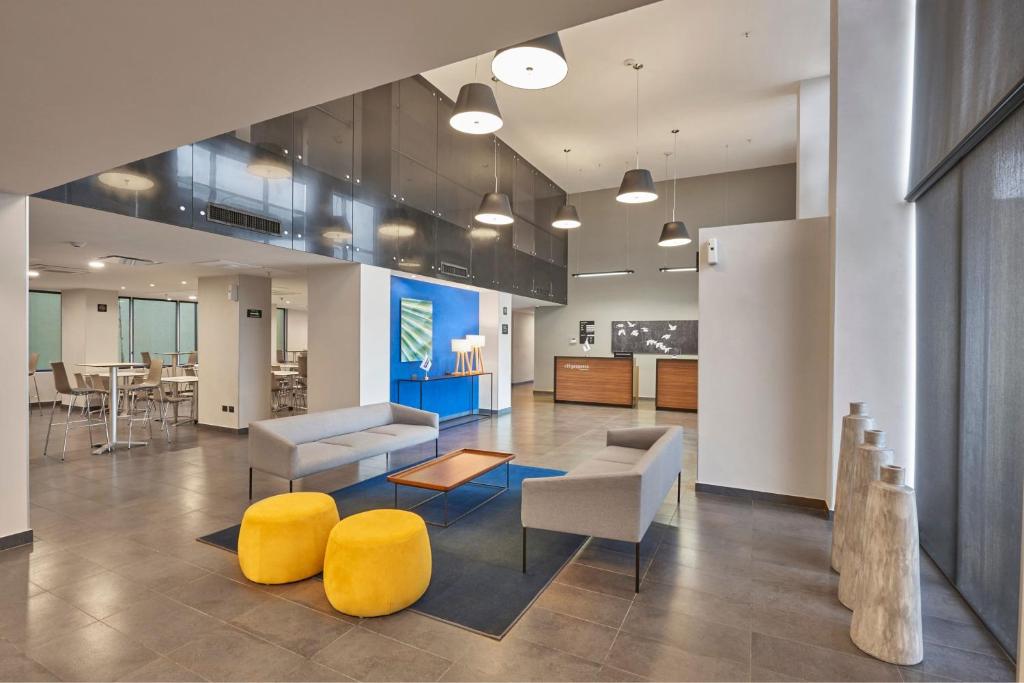 a lobby with couches and chairs and a table at City Express by Marriott Tampico Altamira in Tampico