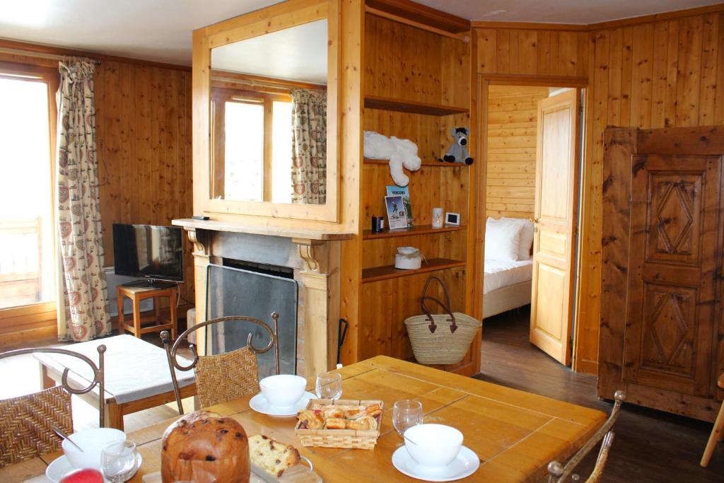 a dining room with a table and a kitchen at Appartement Solaise Plein Sud By Valdiski in Val dʼIsère