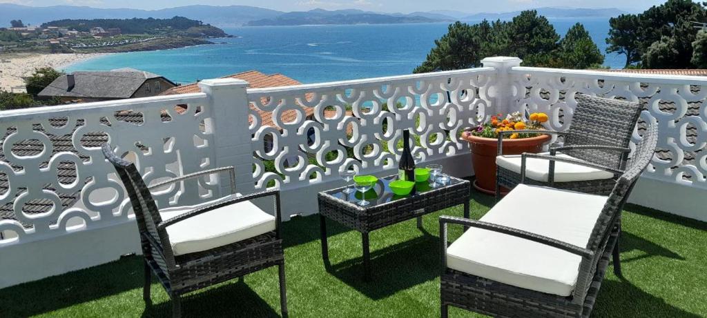 Un balcón con sillas y vistas al océano. en La Cruz del Sur en Sanxenxo