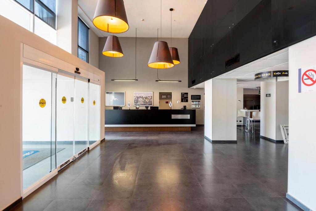 an empty lobby of a building with pendant lights at City Express by Marriott Paraiso in Paraíso