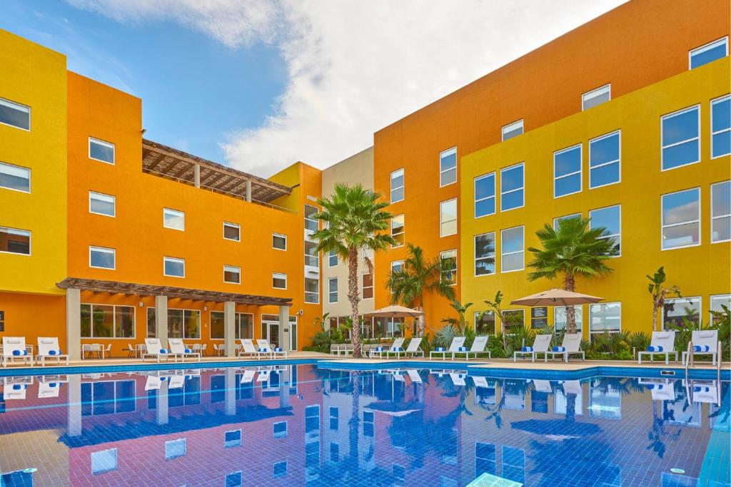 una piscina frente a un edificio en City Express Suites by Marriott Cabo San Lucas, en Cabo San Lucas
