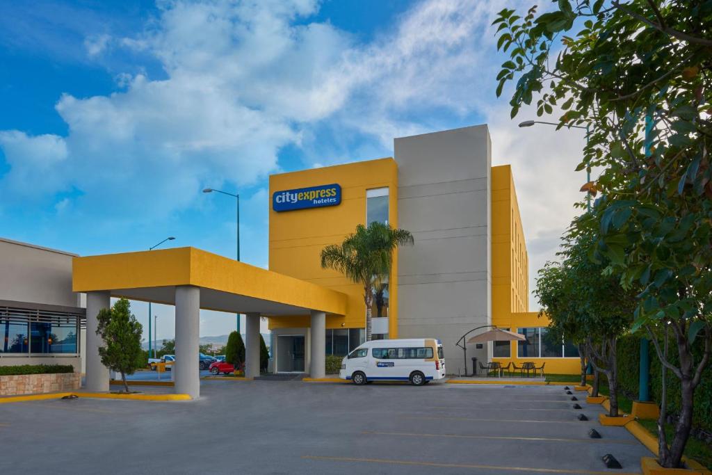 een auto geparkeerd op een parkeerplaats voor een winkel bij City Express by Marriott San Luis Potosi Zona Industrial in San Luis Potosí