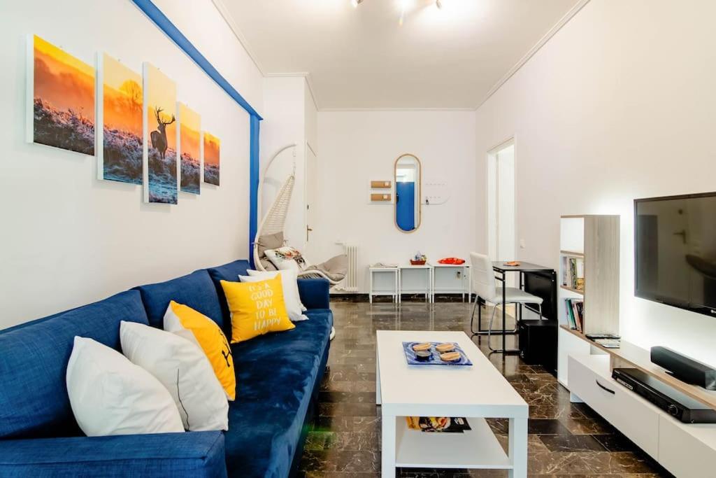 uma sala de estar com um sofá azul e uma televisão em Athens Paradise Apartament 50 sqm Near To Metro #2 em Atenas