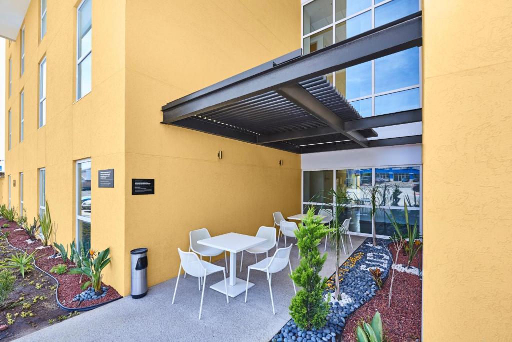 a patio with a table and chairs in front of a building at City Express by Marriott Rosarito in Rosarito