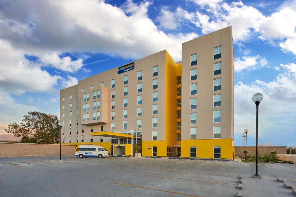 hotel z samochodem zaparkowanym przed nim w obiekcie City Express by Marriott Ensenada w mieście Ensenada