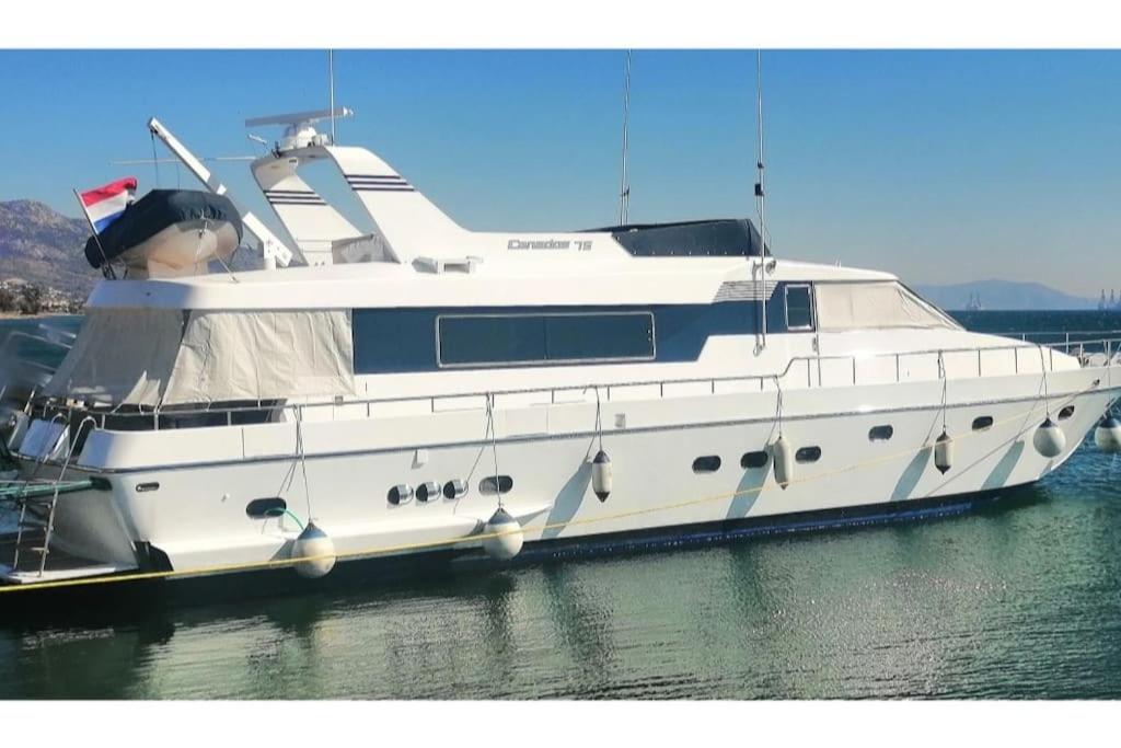 una grande barca bianca seduta in acqua di Luxury Vacations, Accommodation a Néa Péramos