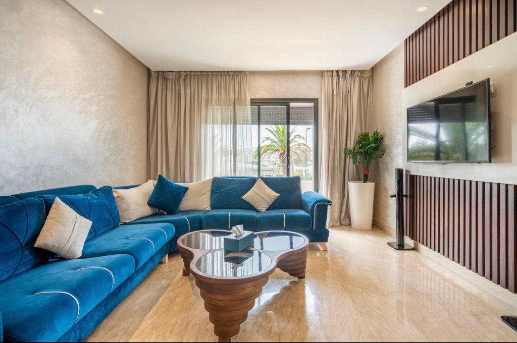 a living room with a blue couch and a table at Incantevole Luxury apprt nel cuore di Casablanca in Casablanca