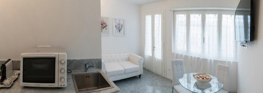 a white living room with a tv and a couch at Althea in Viareggio