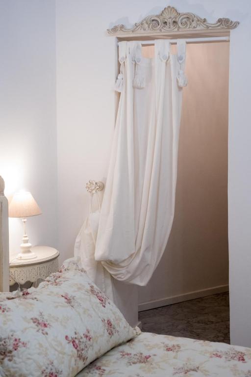 a bedroom with a bed with white curtains at Althea in Viareggio