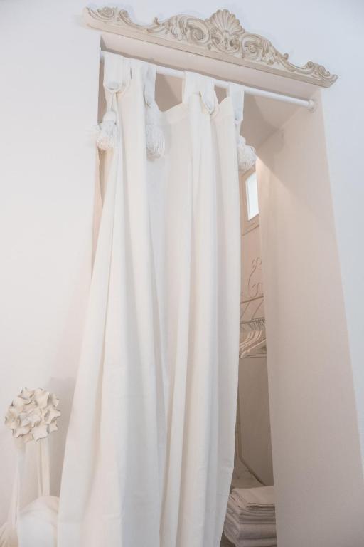 a white curtain in a room with a bed at Althea in Viareggio