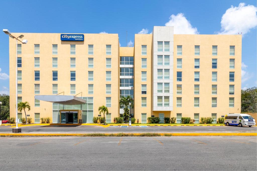 un gran edificio con una furgoneta estacionada frente a él en City Express by Marriott Chetumal, en Chetumal