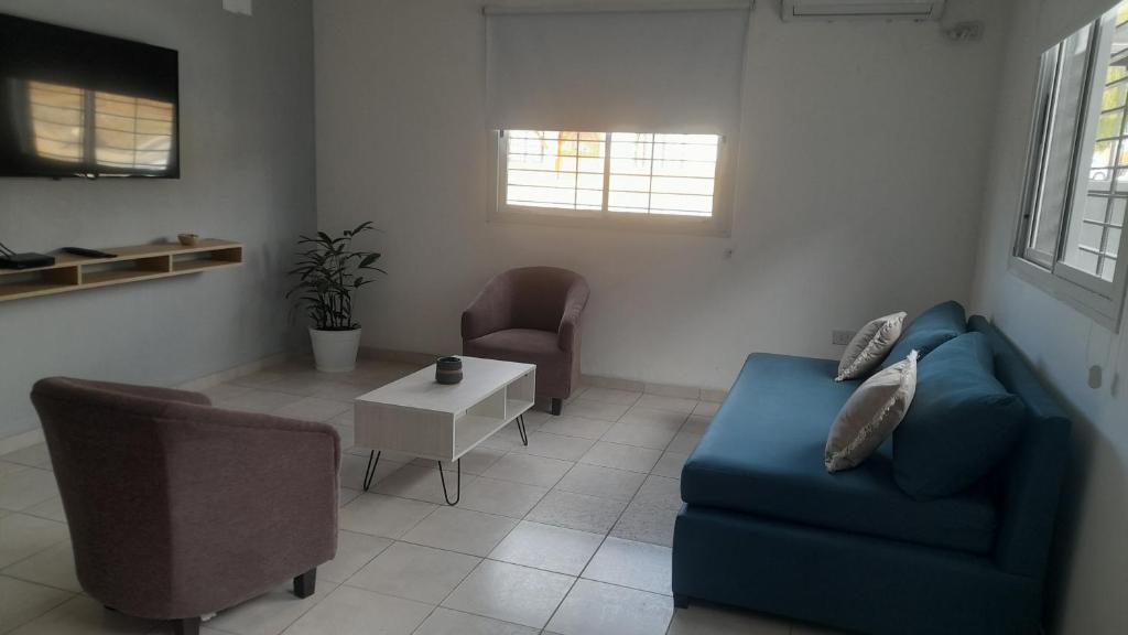 ein Wohnzimmer mit einem blauen Sofa und einem Tisch in der Unterkunft DEPARTAMENTO URBANO EL CHALLAO in Mendoza