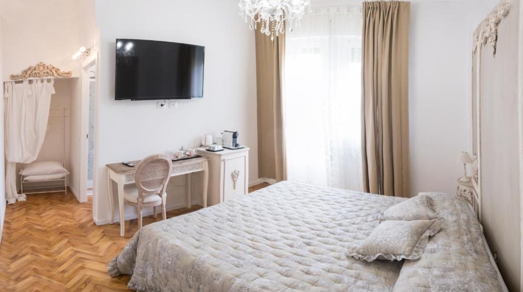 a bedroom with a bed and a desk and a tv at Althea in Viareggio