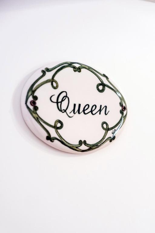 a white oval sign with the word queen at Althea in Viareggio