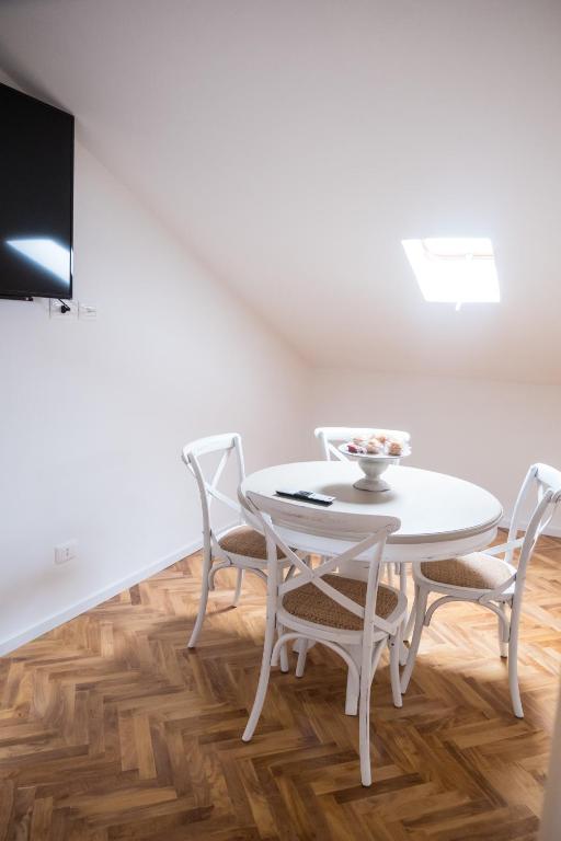 a white dining room with a white table and chairs at Althea in Viareggio
