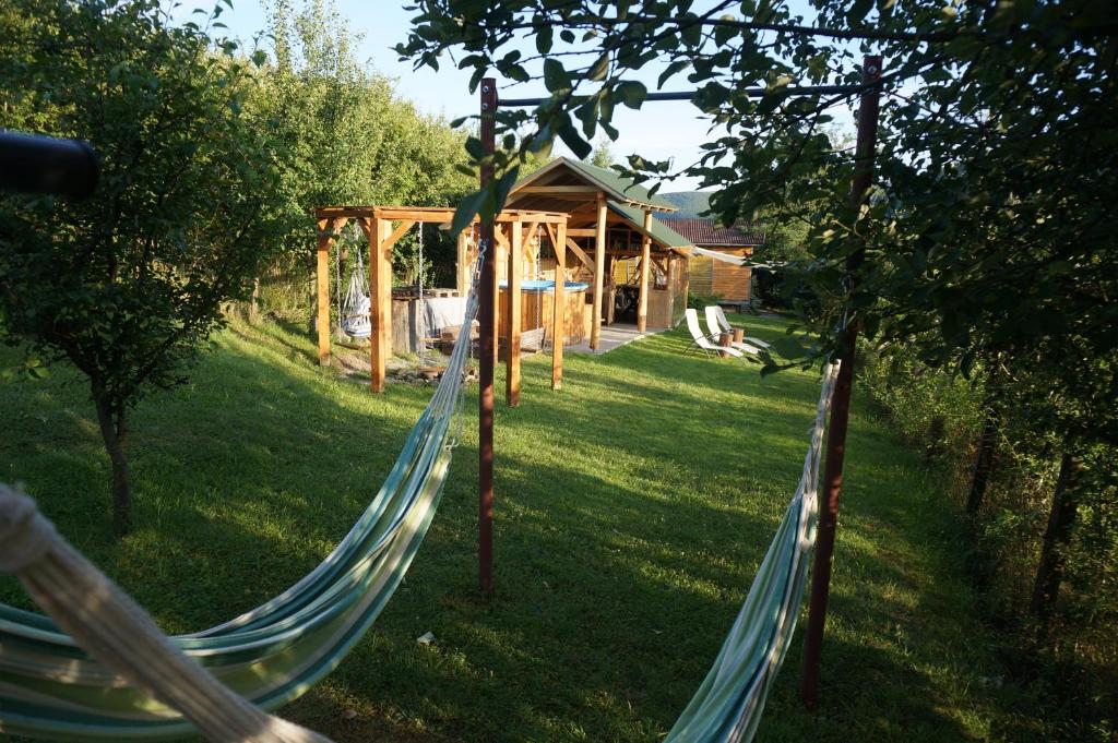 una hamaca en un patio con una cabaña en Natura Chalets, en Praid