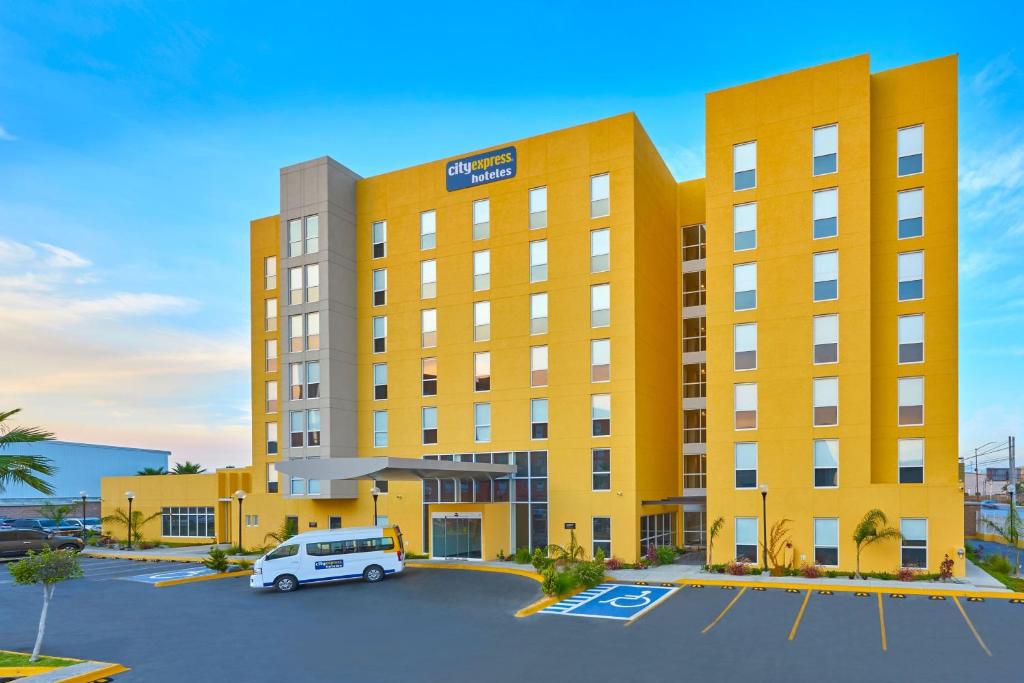 Un hôtel avec une voiture garée dans un parking dans l'établissement City Express by Marriott Tijuana Otay, à Tijuana