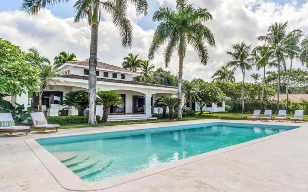 una piscina frente a una casa con palmeras en Sunny Vacation Villa No 53, en San Rafael del Yuma