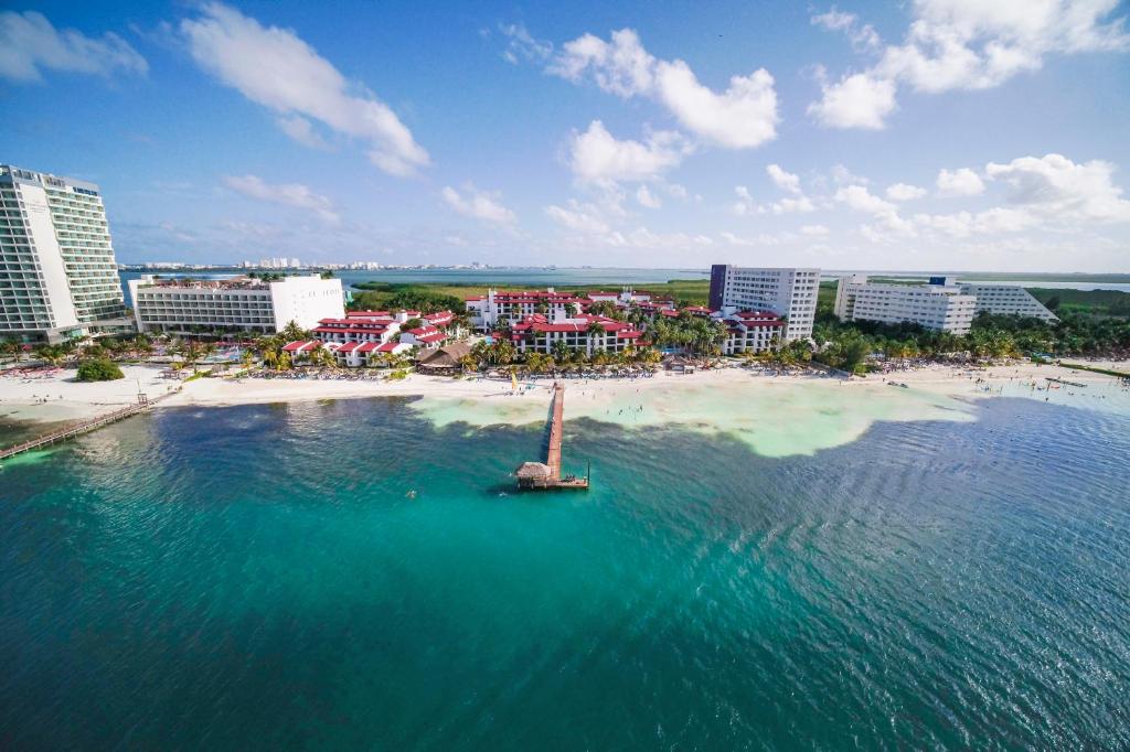 una vista aérea de una playa con un barco en el agua en The Royal Cancun All Suites Resort - All Inclusive, en Cancún