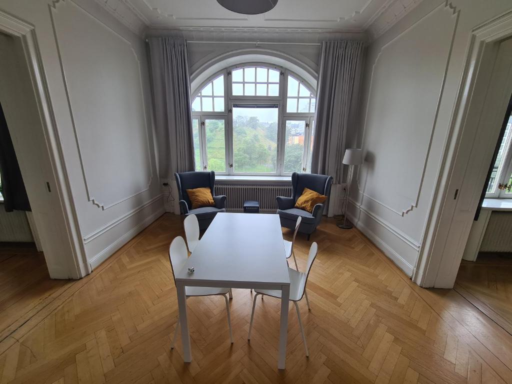 a living room with a table and chairs and a window at Home Inn SVG108 in Stockholm