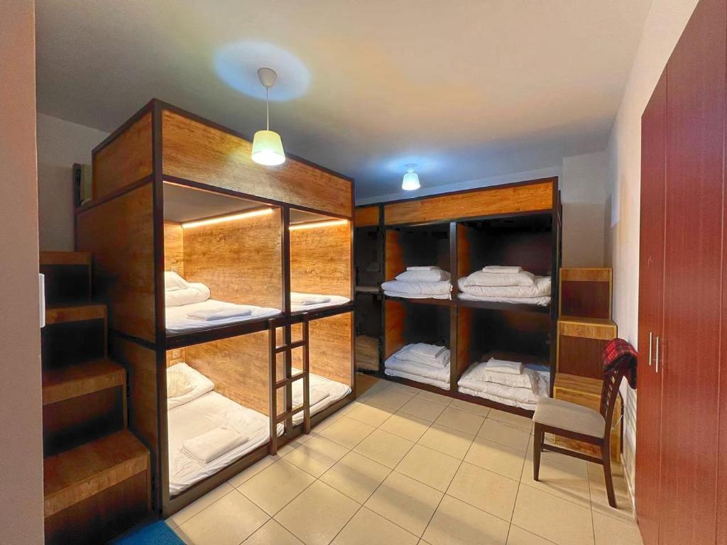 Palm view hostel في دبي: غرفة مع غرفة مع أسرة بطابقين خشبية