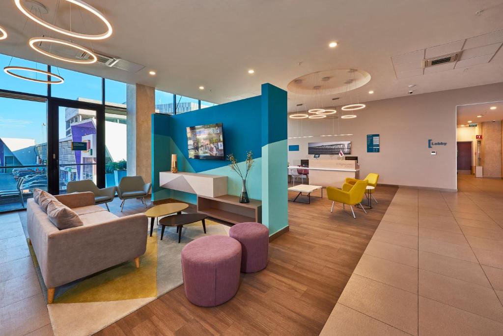 an office with a lobby with chairs and tables at City Express Suites by Marriott Tijuana Rio in Tijuana