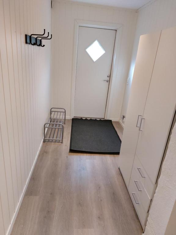 ein leeres Zimmer mit einer Tür und einem Teppich in der Unterkunft Herasbygda 