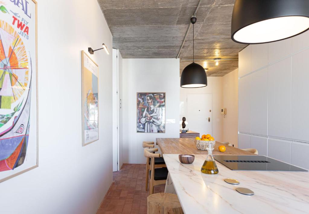 eine Küche und ein Esszimmer mit einem großen Holztisch in der Unterkunft Columbano Suites Hotel Lisboa - Praça de Espanha, Sete Rios - Bookable parking in Lissabon