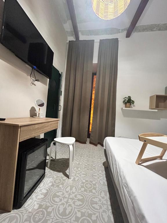 1 dormitorio con 1 cama, TV y silla en Casa la cava, en Taranto