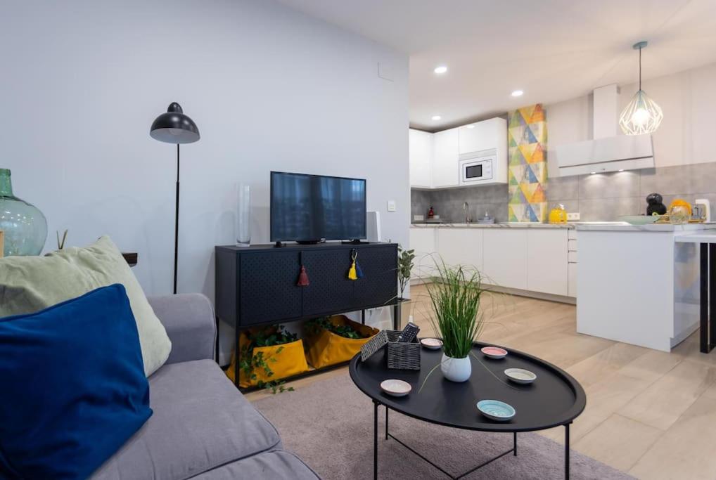 ein Wohnzimmer mit einem Sofa und einem Tisch in der Unterkunft Apartamento tranquilo y céntrico en Santander in Santander