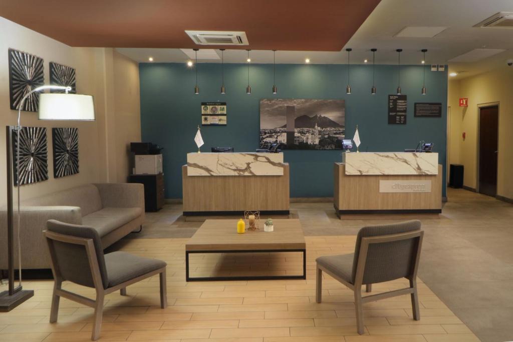 een lobby met 2 stoelen, een tafel en een bar bij City Express Plus by Marriott Monterrey Galerías in Monterrey