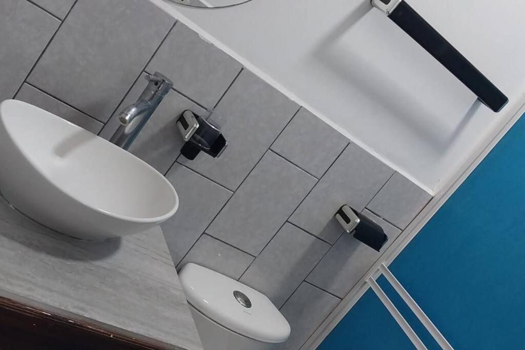 La salle de bains est pourvue de toilettes blanches et d'un lavabo. dans l'établissement Casa Tierra Viva, à Managua