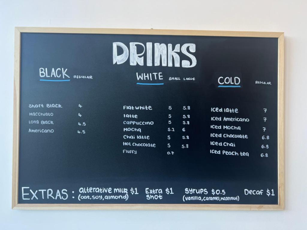 a chalkboard sign for drinks at a restaurant at Manha Hotel Auckland Airport in Auckland