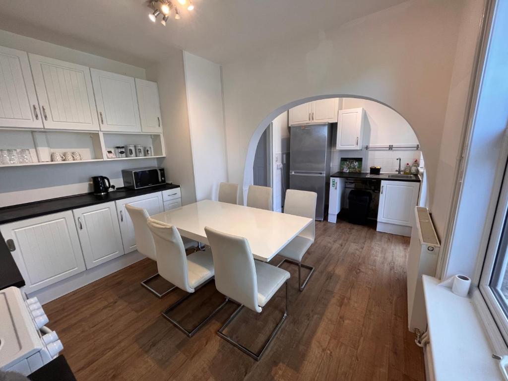 a kitchen and dining room with a white table and chairs at Spacious 3bed house in Southend-on-Sea