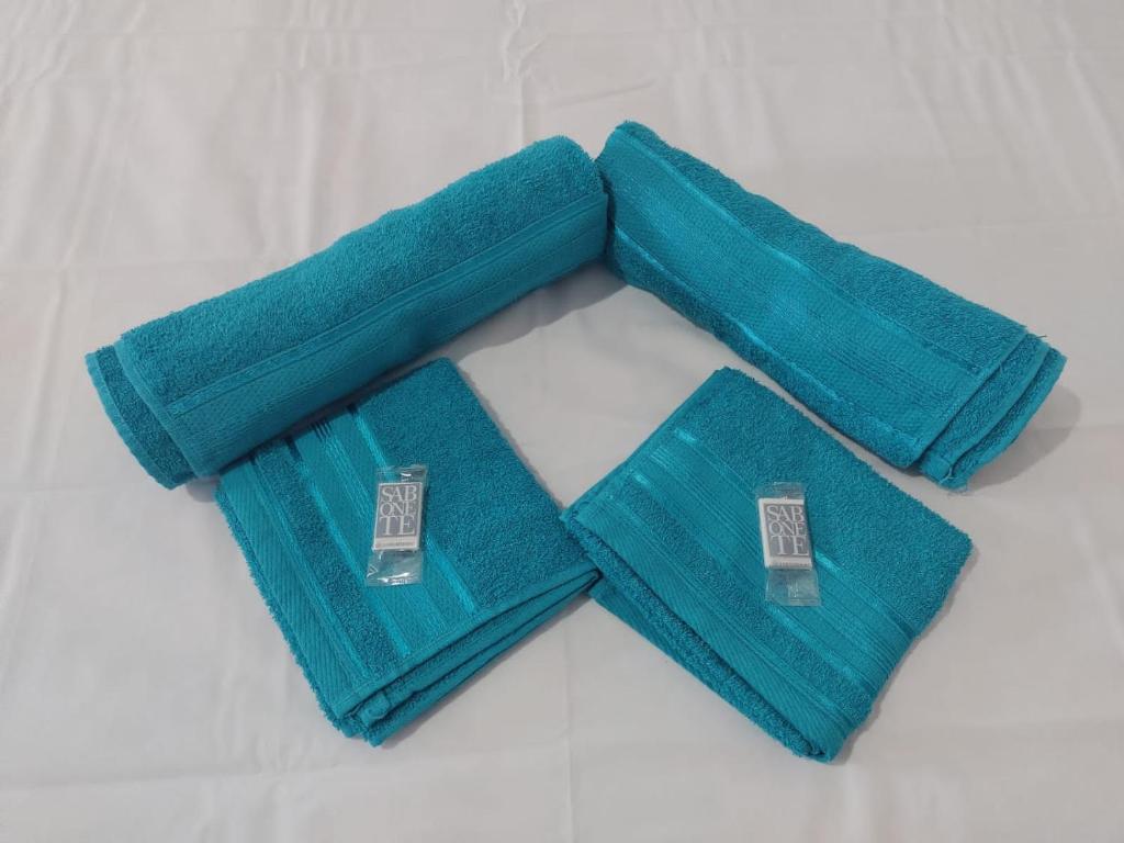 two turquoise towels sitting on top of a table at Chalés relíquia canastra in São Roque de Minas