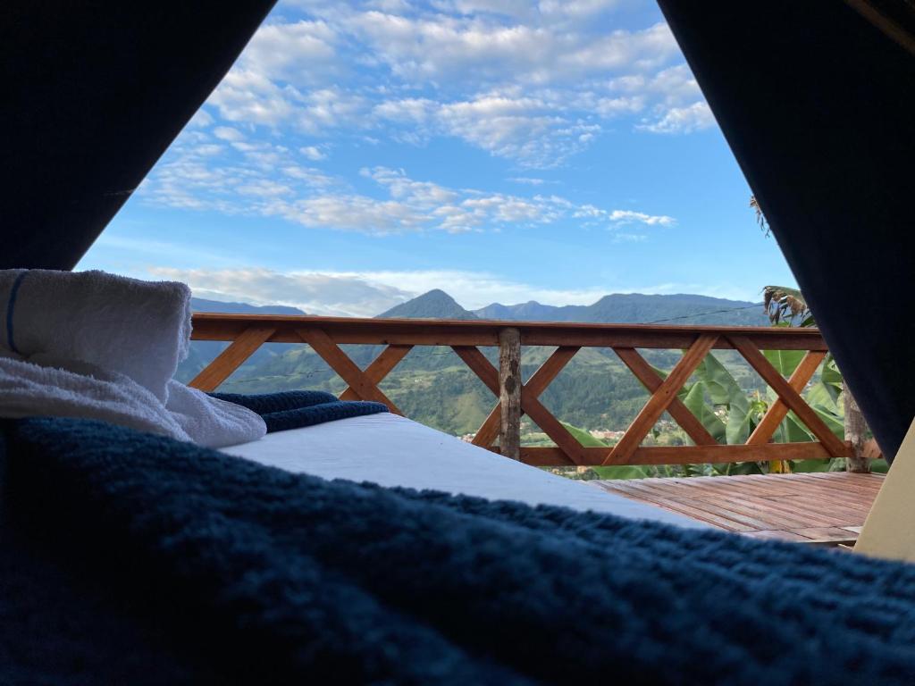 a bed in a tent with a view of the mountains at Origlamping Noche De Luna in Jardin