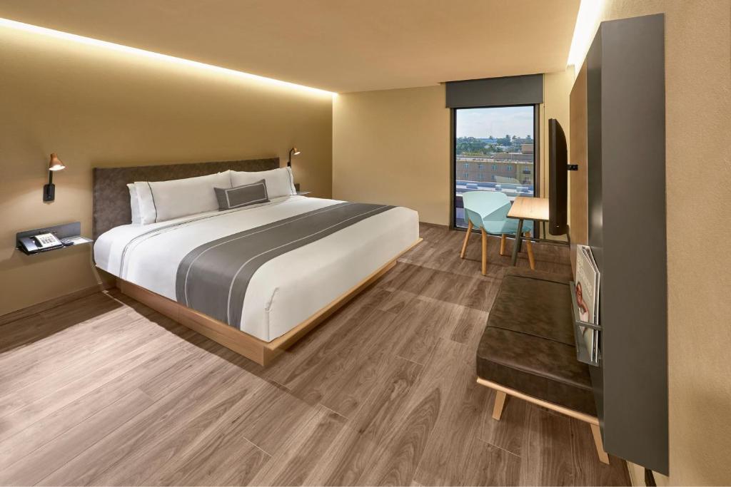 een hotelkamer met een bed en een raam bij City Express Plus by Marriott Tampico in Tampico
