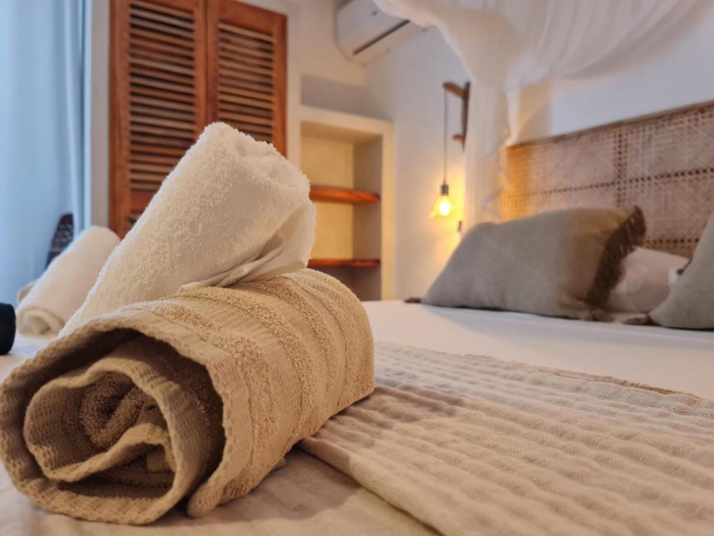 a towel sitting on top of a bed at o'Filao in Grand-Bourg