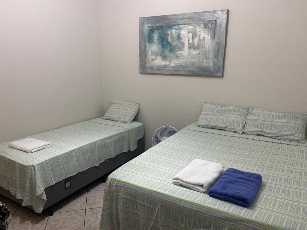 two beds sitting next to each other in a room at Apartamento para 8 pessoas próximo a Basílica in Aparecida
