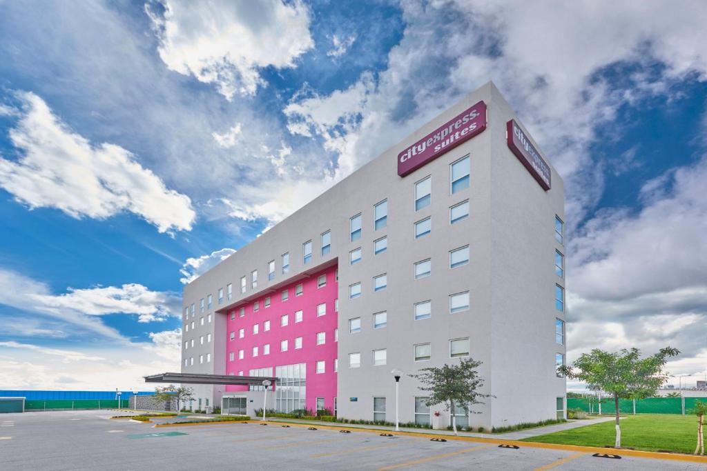 a hotel with a red and white building at City Express Suites by Marriott Silao Aeropuerto in Silao