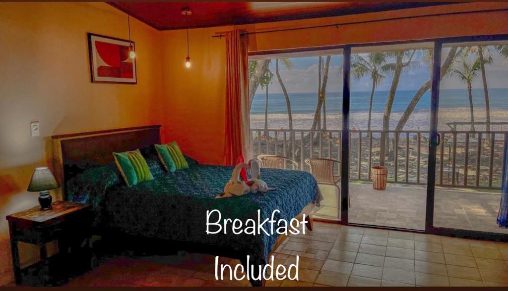 Schlafzimmer mit einem Bett und Strandblick in der Unterkunft Hotel Beachfront Vista Hermosa in Jacó