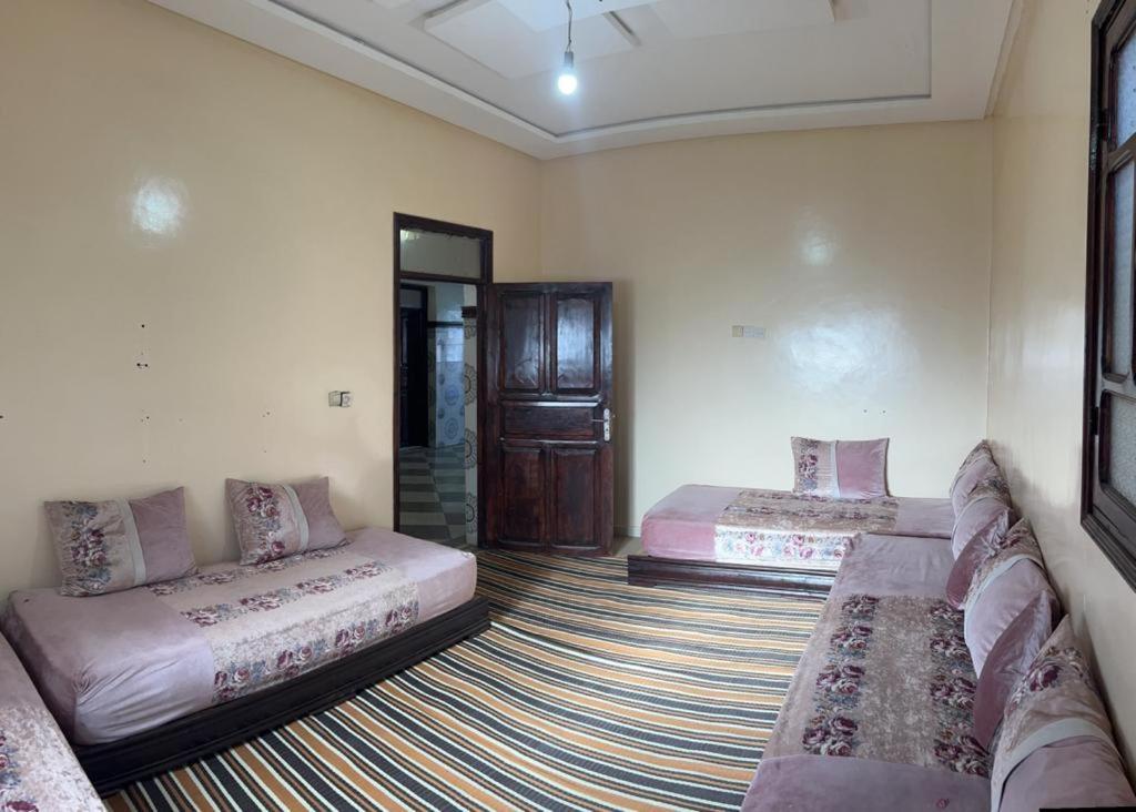 een woonkamer met 2 bedden en een bank bij Panorama de l'Atlas in Marrakesh