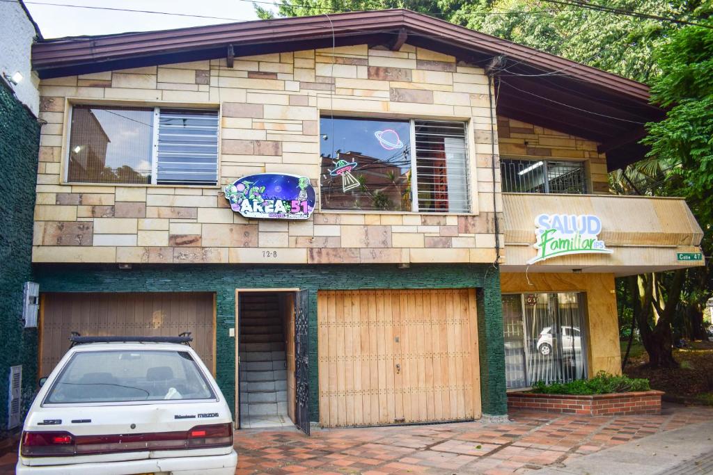 a building with a car parked in front of it at AREA 51 HOSTEL in Medellín