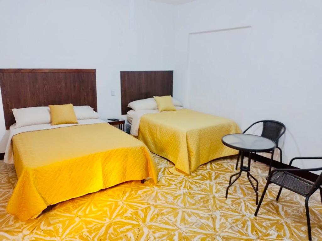 Habitación con 2 camas, mesa y sillas en Villas Cairo, en Guatemala