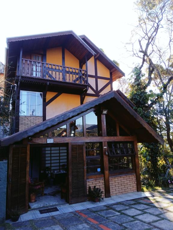 ein Haus mit Balkon darüber in der Unterkunft Pousada Le Lieu in Santo Antônio do Pinhal