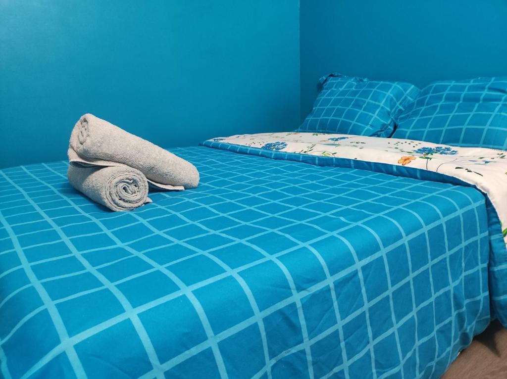 Una cama azul con una manta y almohadas. en Paris cosy private room with shared space - Chambre privée avec espace commun Paris, en Vitry-sur-Seine